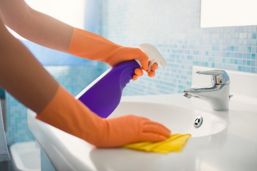 Cleaner wearing PPE while operating carpet cleaning equipment
